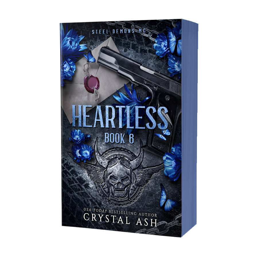 Book cover of 'Heartless' by Crystal Ash with a gun, skull, and blue flowers on a dark background.